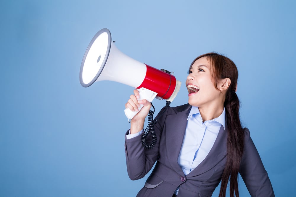 Businesswoman making announcement with megaphone Businesswoman making announcement with megaphone